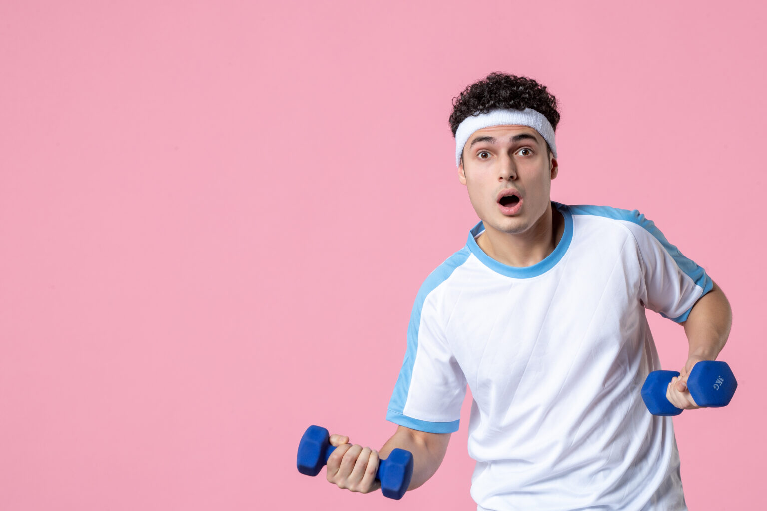 Front View Young Male Sport Clothes Working Out With Dumbbells Pink Wall 1536x1024
