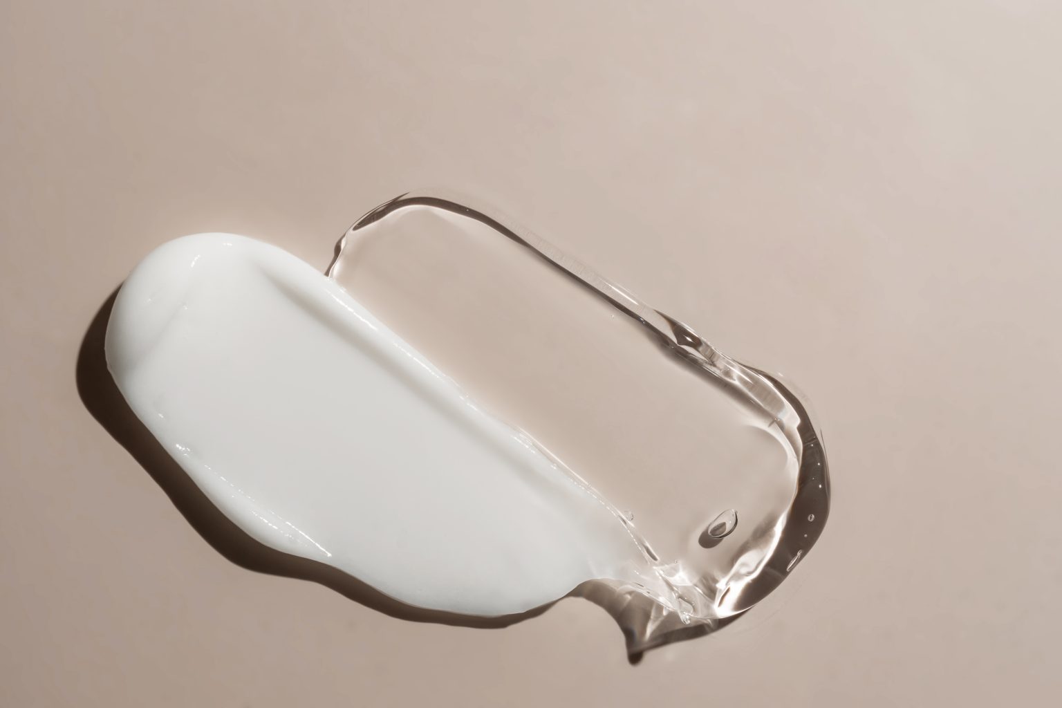liquid cream and gel cosmetic smudge drops texture on beige background. cosmetic smears cream texture. skin care product stroke flat lay, cream with hyaluronic acid