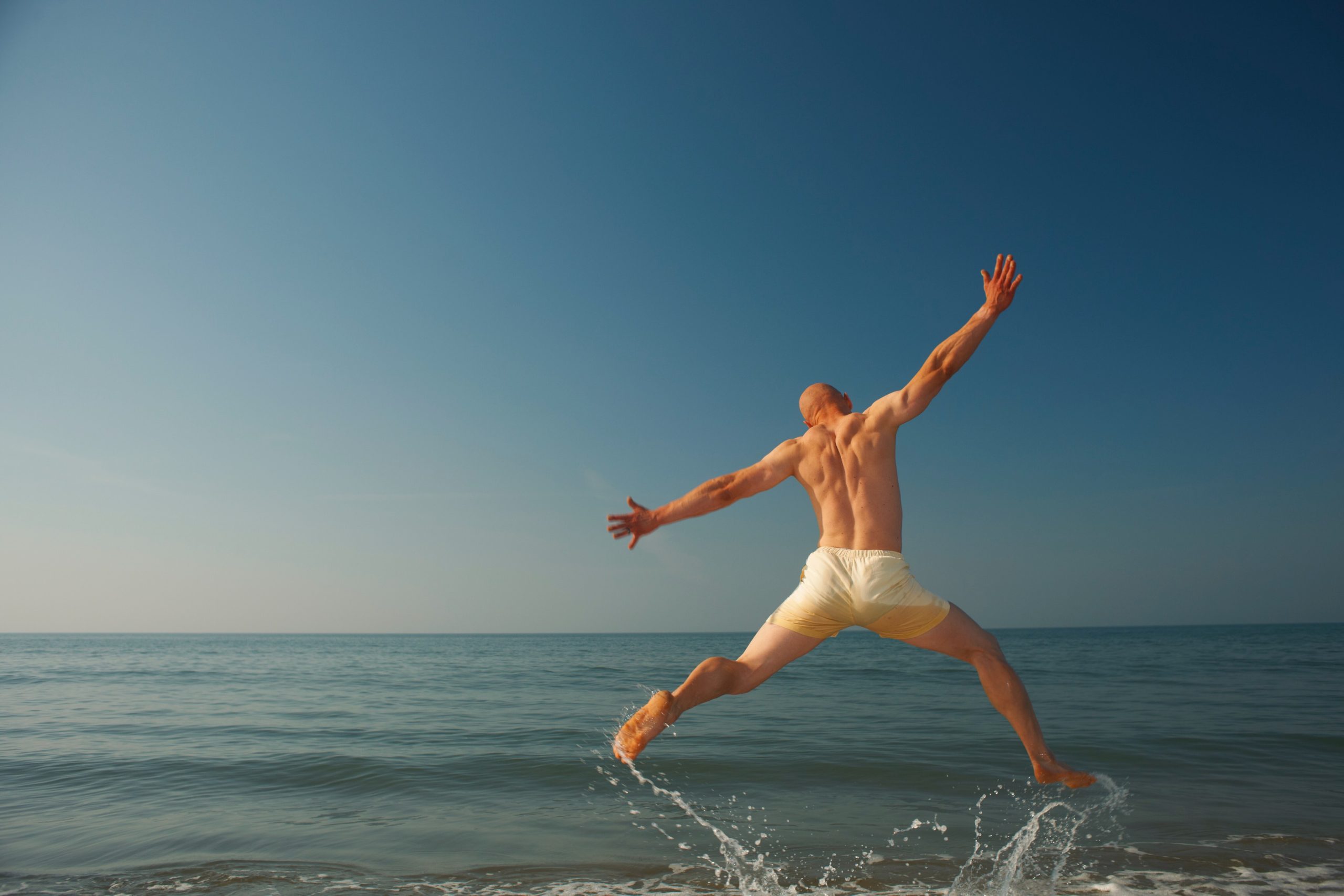mid adult man jumping outstretched over sea 2025 04 04 20 30 22 utc (1)