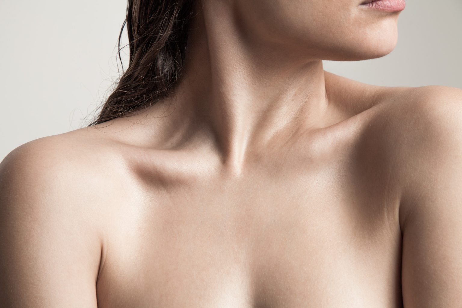 Close-up of woman's neck and shoulder skin showing natural elasticity and firmness
