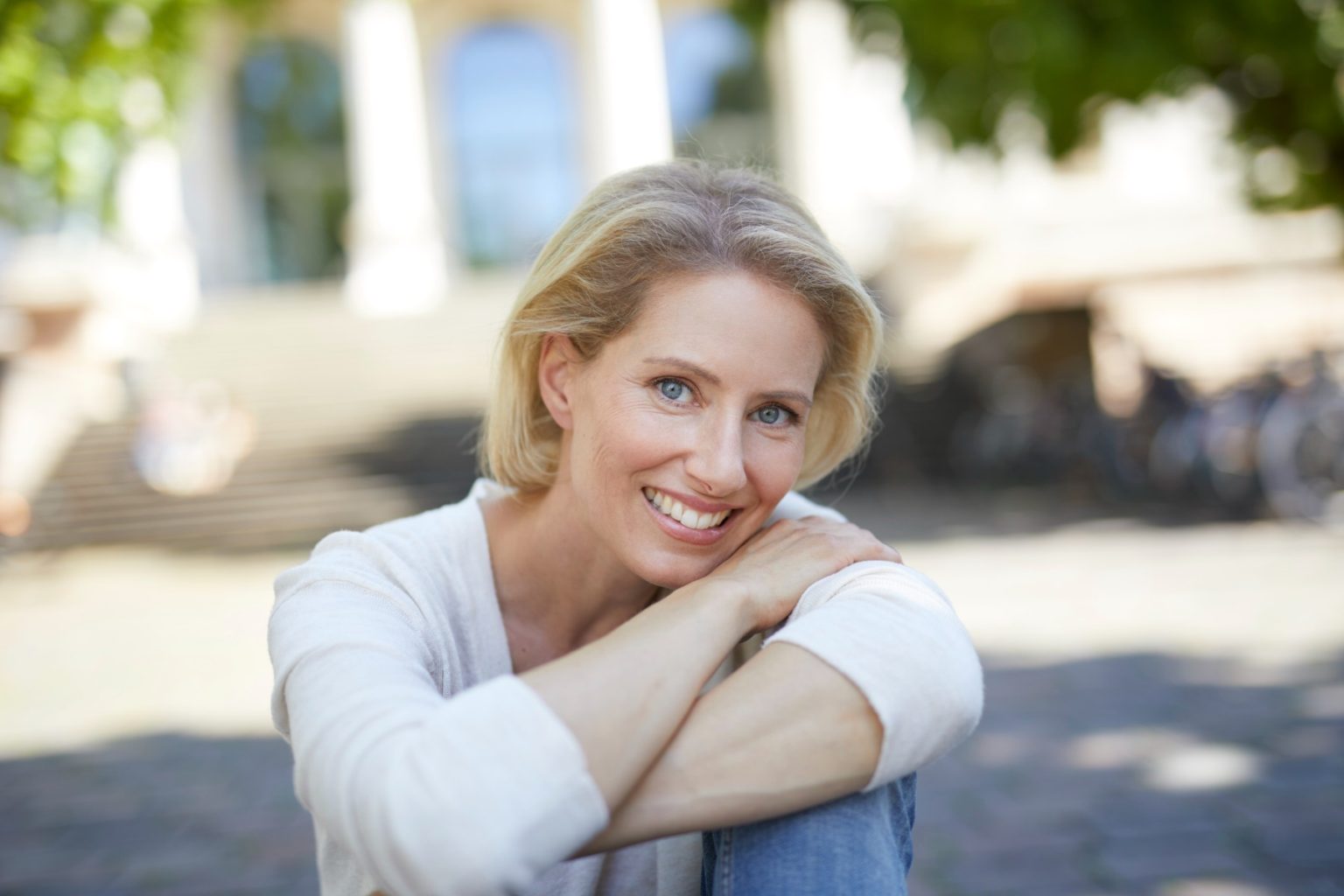 Healthy midlife woman smiling outdoors in natural light representing graceful aging