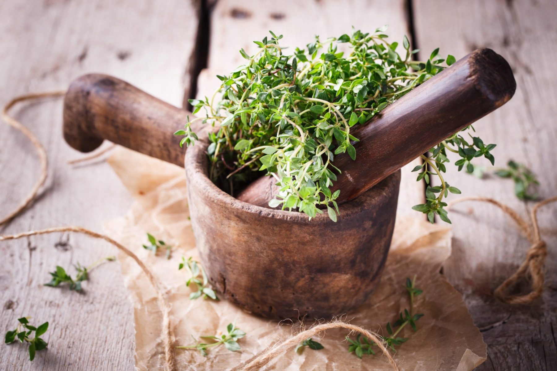 Traditional wooden mortar and pestle used for preparing herbal botanical remedies.